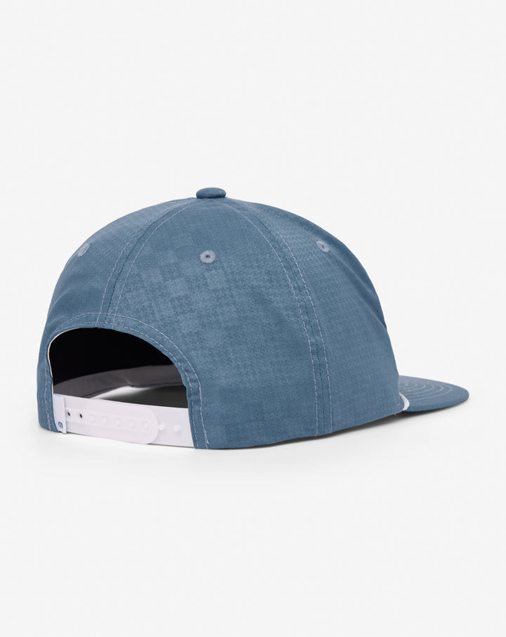TravisMathew Lost Swing Snapback Hat in blue, rear view showing adjustable snapback closure and structured crown.