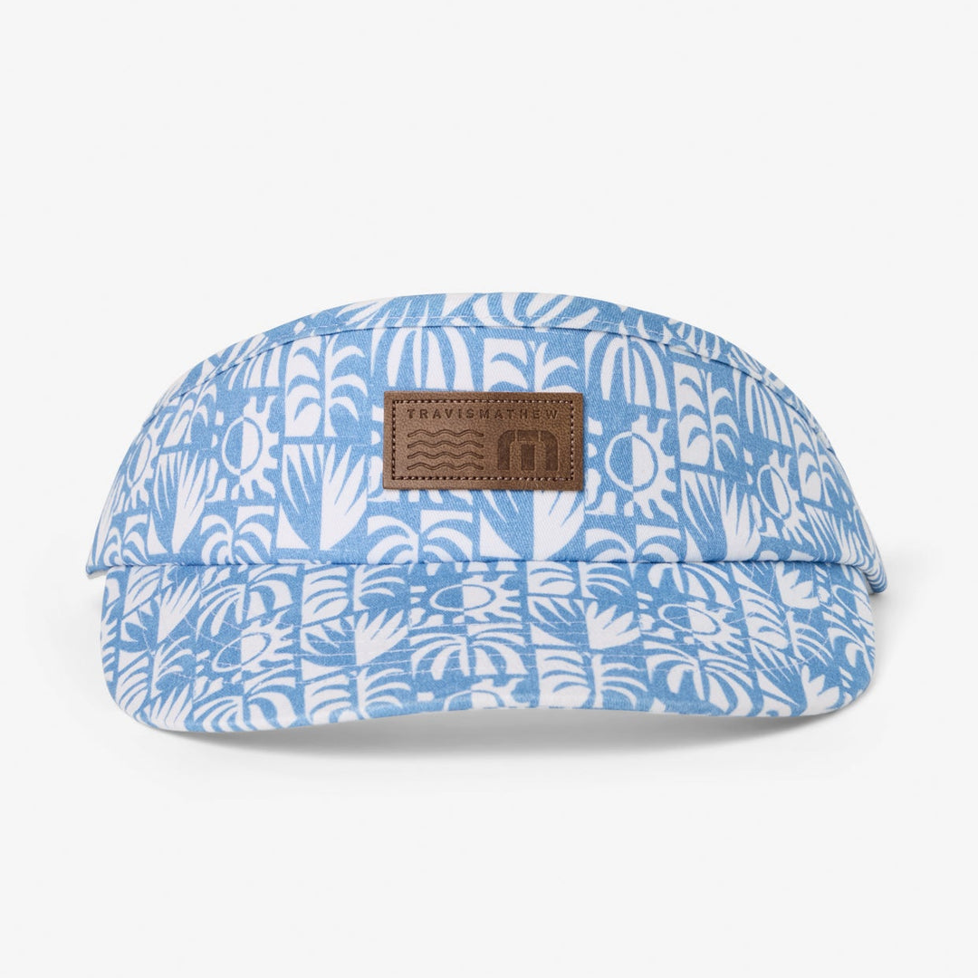 TravisMathew Crazy Weather Visor in blue floral pattern with debossed leather logo patch.