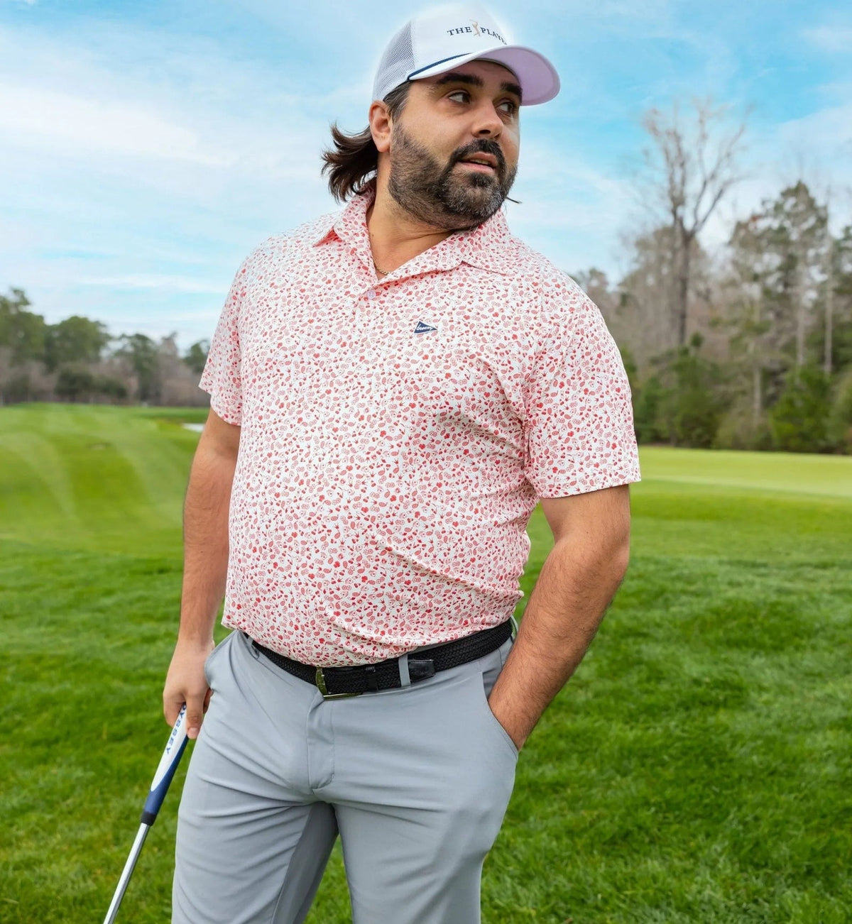 Model wearing Breezy Golf Vegas Baby Polo on course with grey pants and white cap.