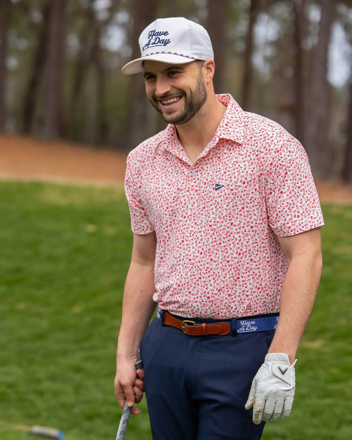 Man wearing Breezy Golf Vegas Baby Polo on golf course, smiling with club in hand.