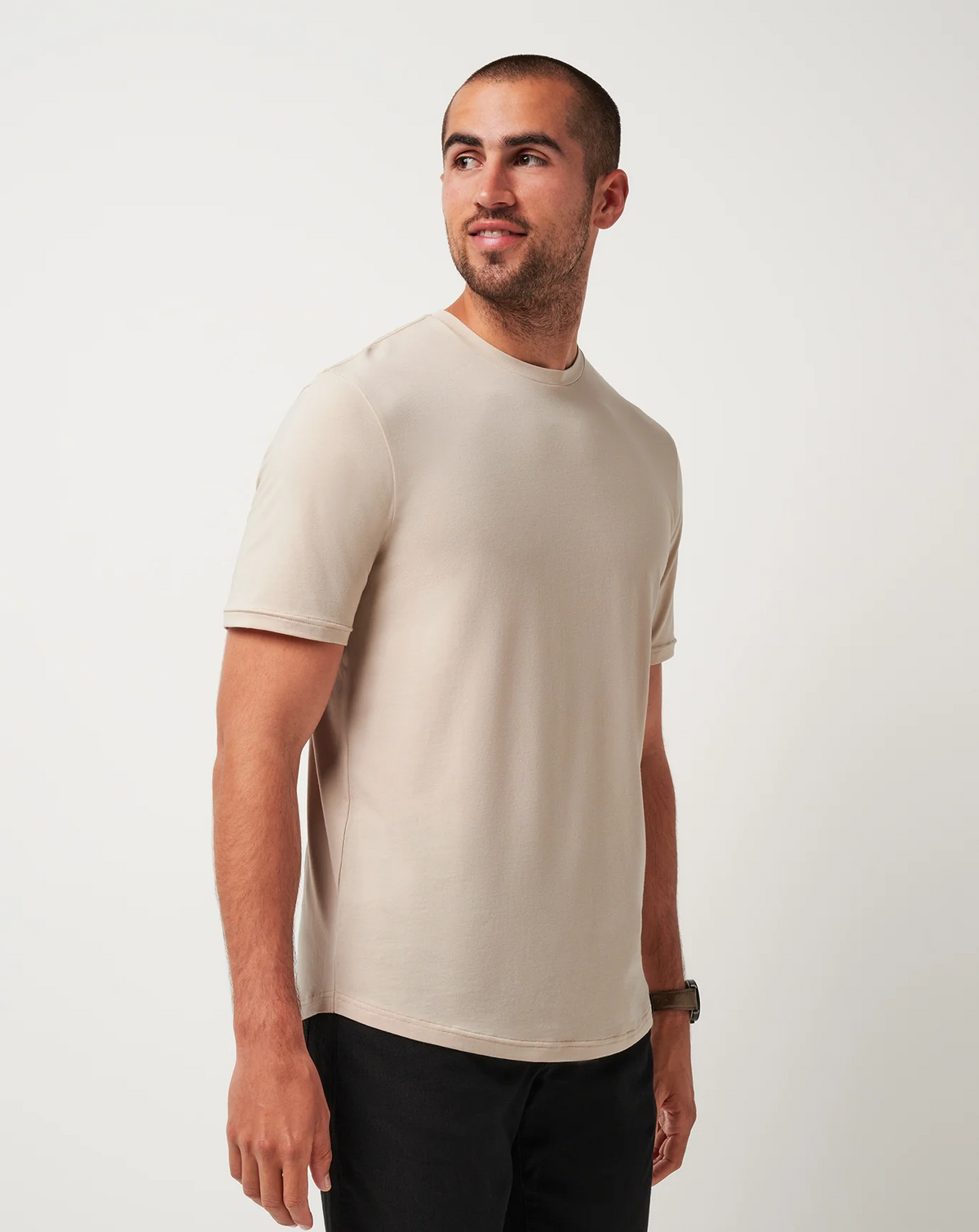 Side angle of the TravisMathew Cloud Crew Tee in Italian Sand worn by a male model