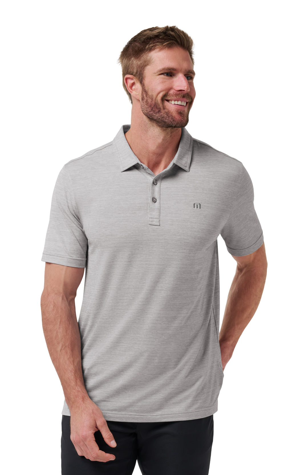 Man wearing a gray TravisMathew Heater polo shirt on a white background