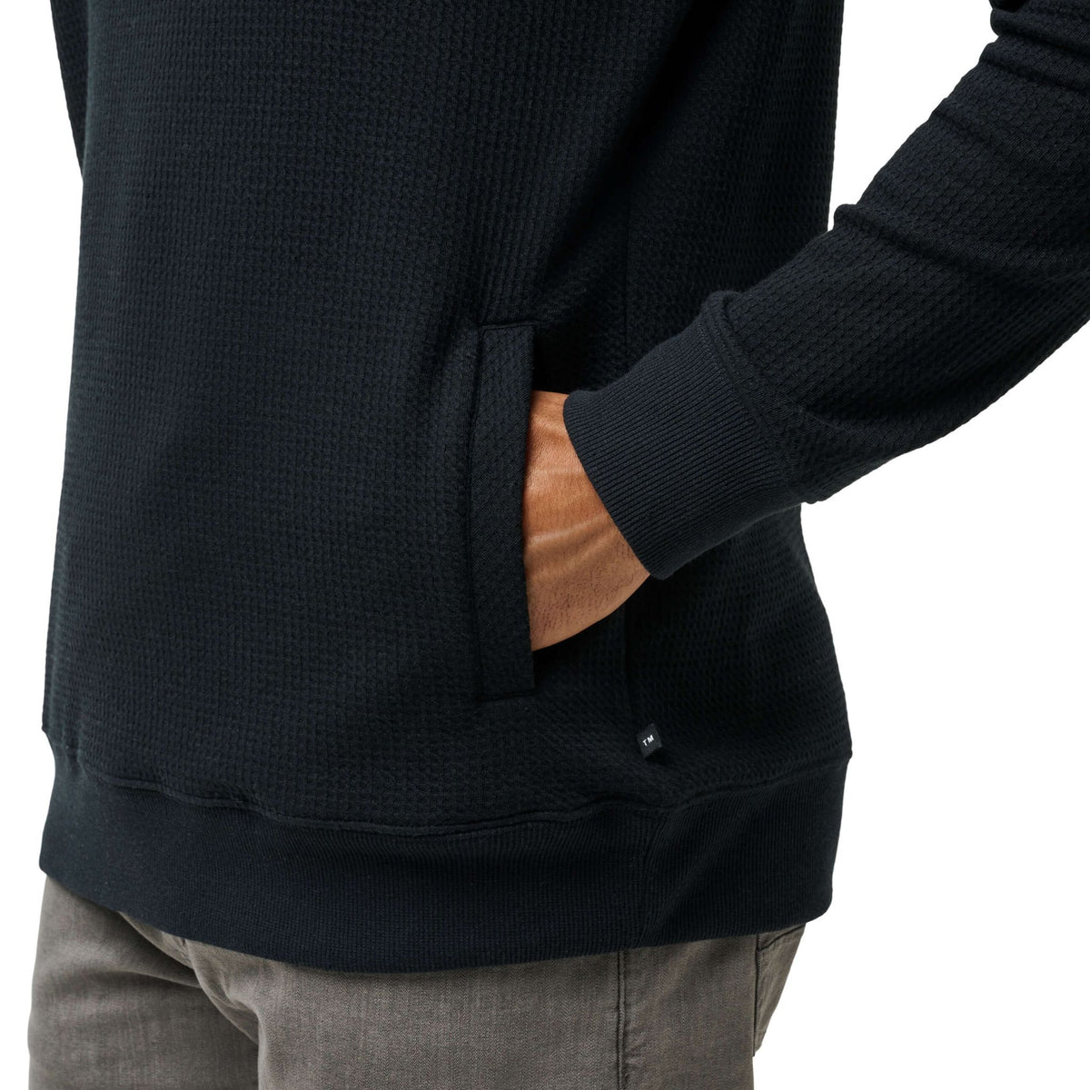 Close-up of men’s black hoodie pocket and hem, highlighting clean finish and premium feel