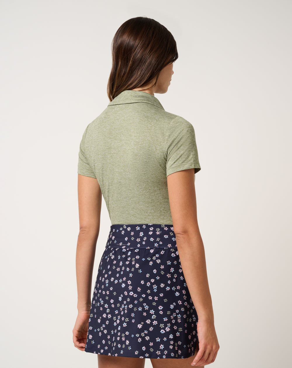 Back view of TravisMathew women’s Skyloft Light Polo in heather oil green.