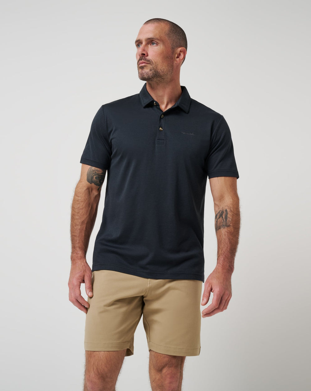 Men wearing Zinna 2.0 performance polo in black, styled with neutral shorts