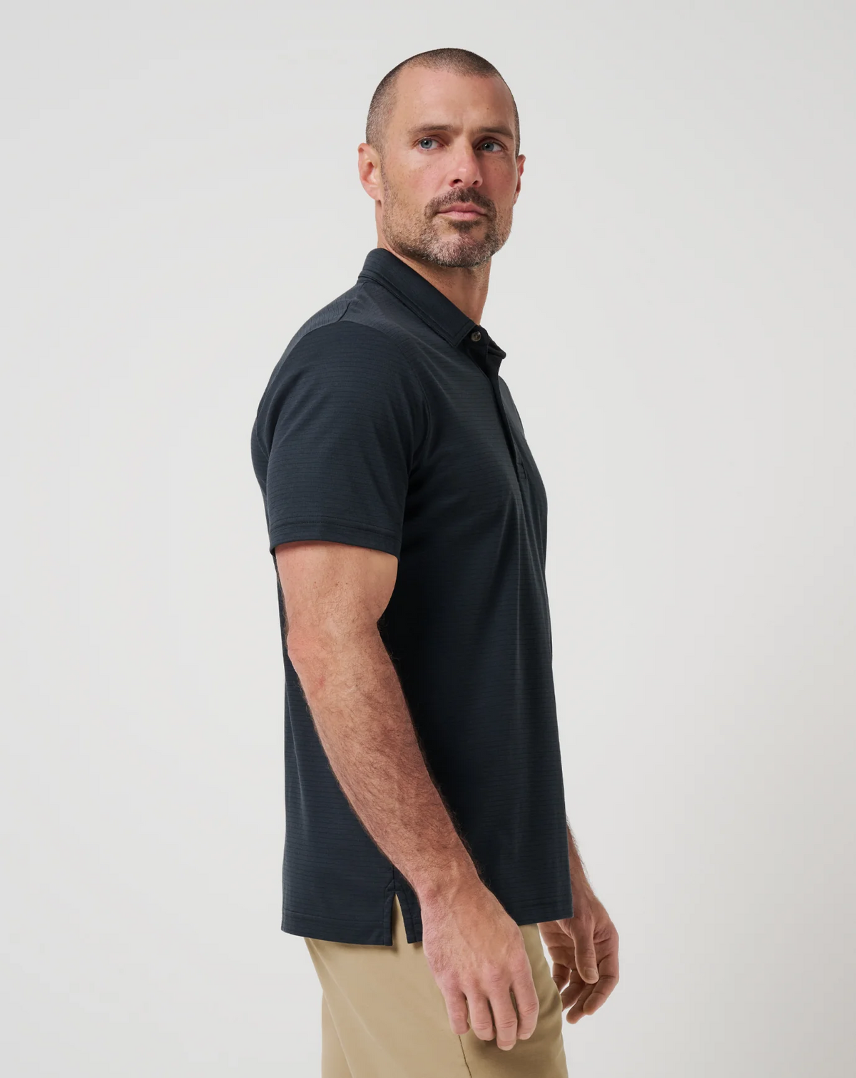 Side view of Zinna 2.0 polo in black showing tailored fit and sleeve length