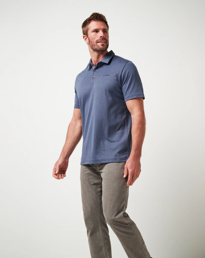 Three-quarter view of model wearing Zinna 2.0 polo in indigo blue with clean drape