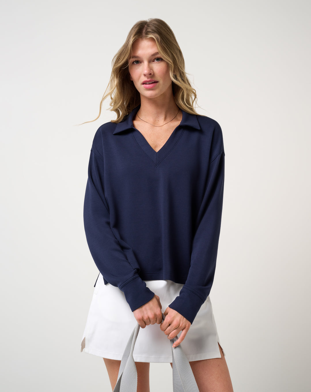 TravisMathew Women's Skyloft Soft V-Neck Pullover navy front styling view with golf skirt
