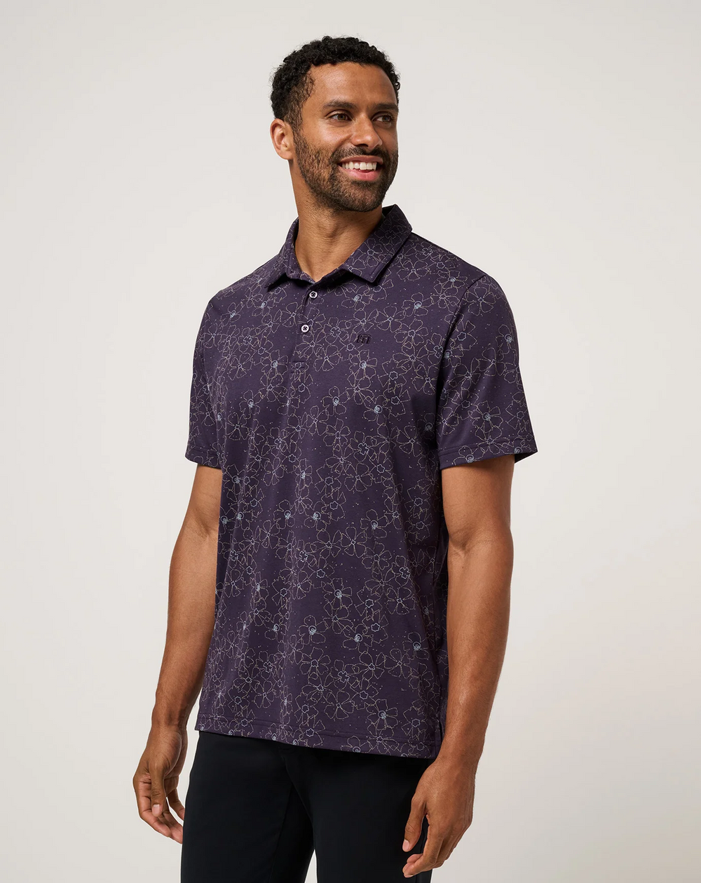 Men wearing TravisMathew Just My Type Polo in purple floral print, angled front view