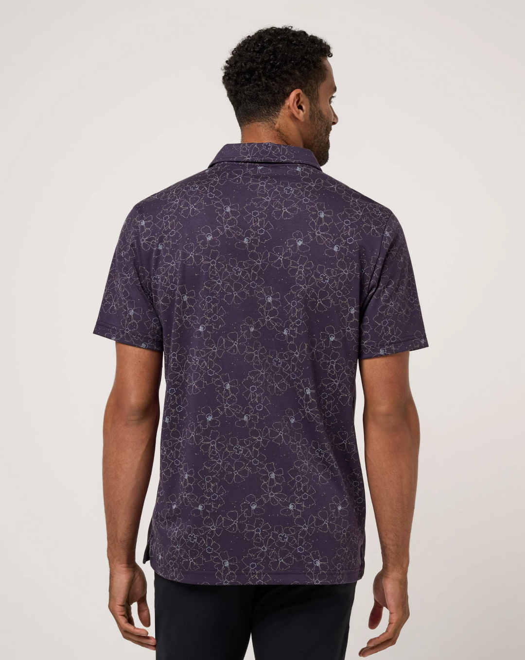 Back view of men’s TravisMathew Just My Type Polo featuring all-over floral line pattern