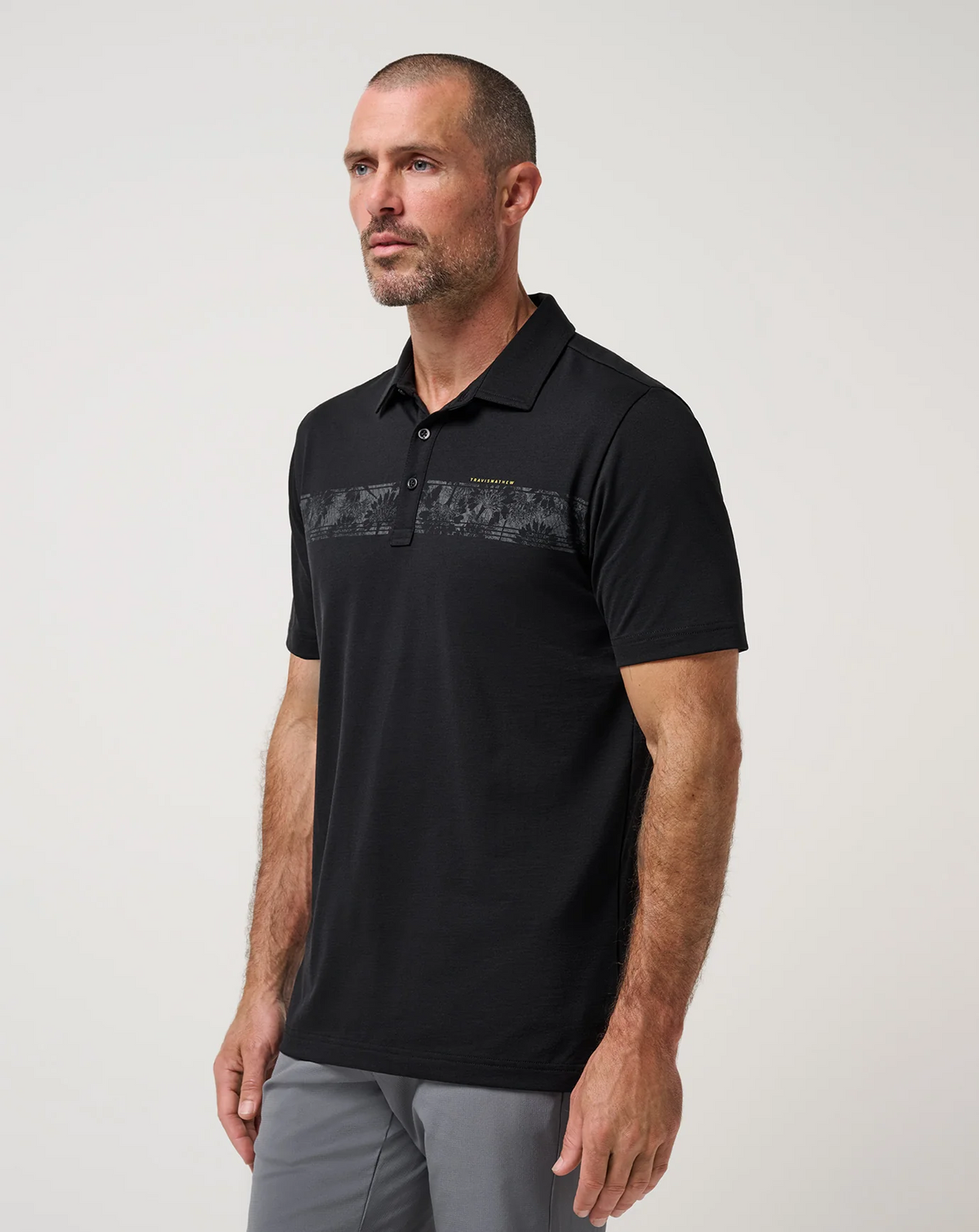 Angled view of the TravisMathew Performance Jersey Flight Polo showing the chest stripe detail 
