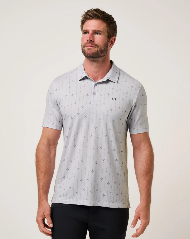 TravisMathew Featherweight Deco Polo in light grey with subtle geometric stripe pattern, shown from the front on model