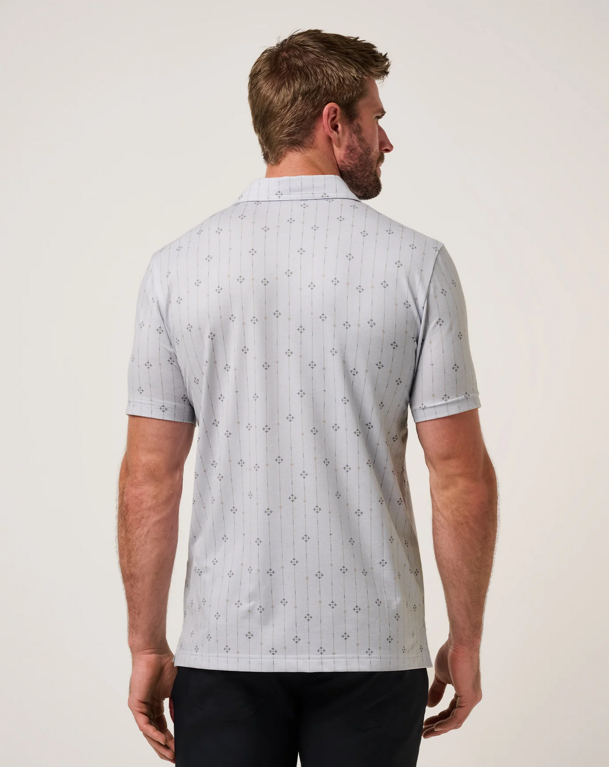 Back view of the TravisMathew Featherweight Deco Polo showcasing the all-over geometric stripe pattern