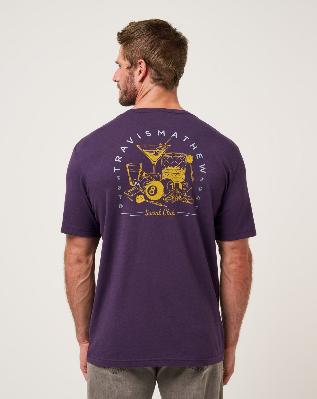 Back view of TravisMathew Social Hour T-Shirt in purple with graphic print