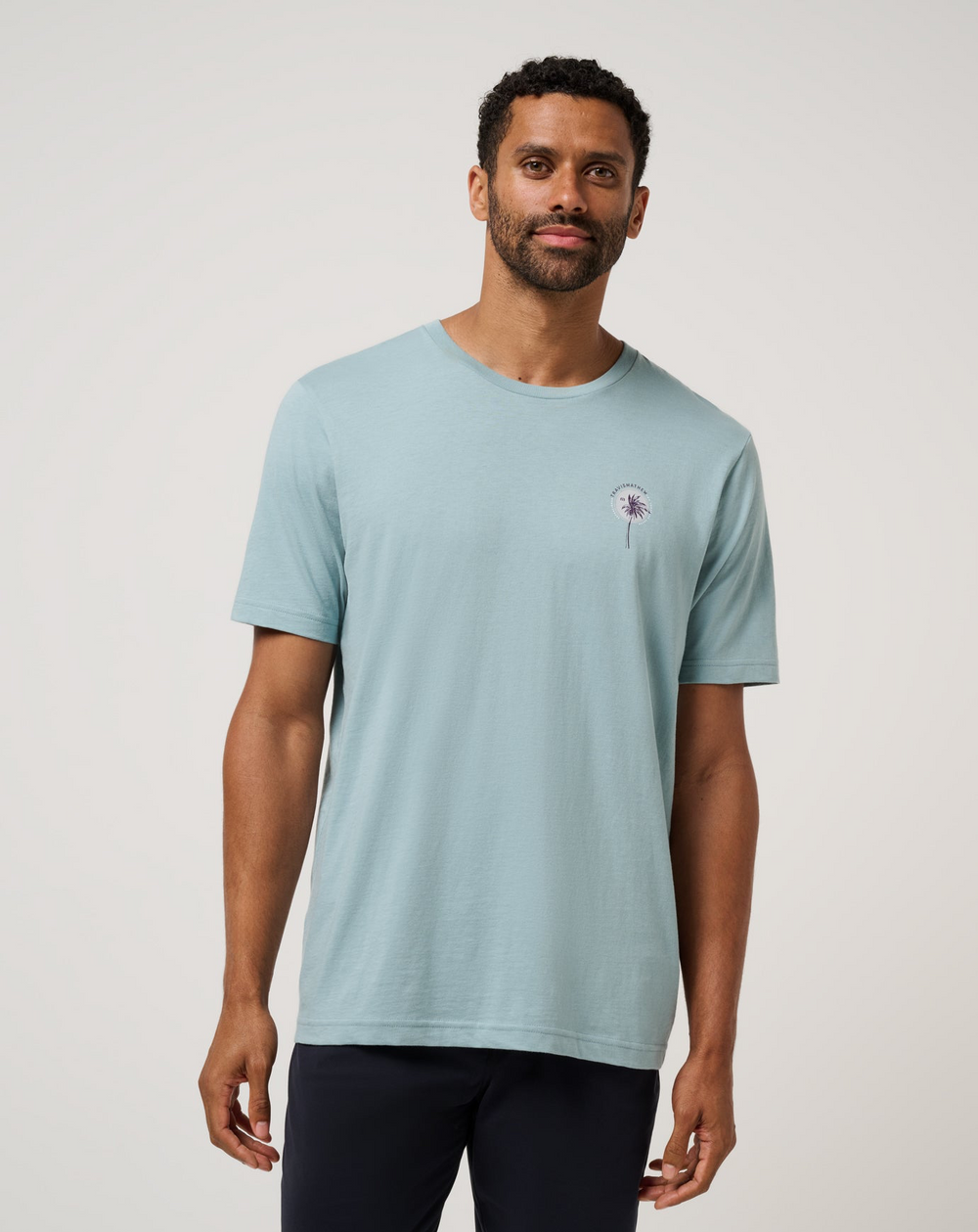 Front view of model wearing TravisMathew Hold My Calls Tee in light blue