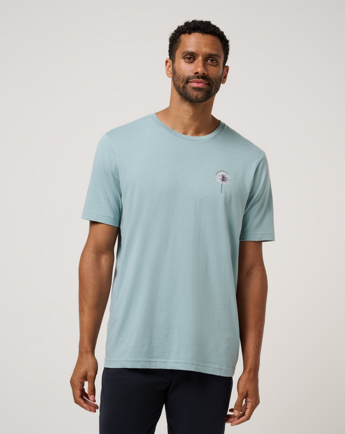 Front view of model wearing TravisMathew Hold My Calls Tee in light blue