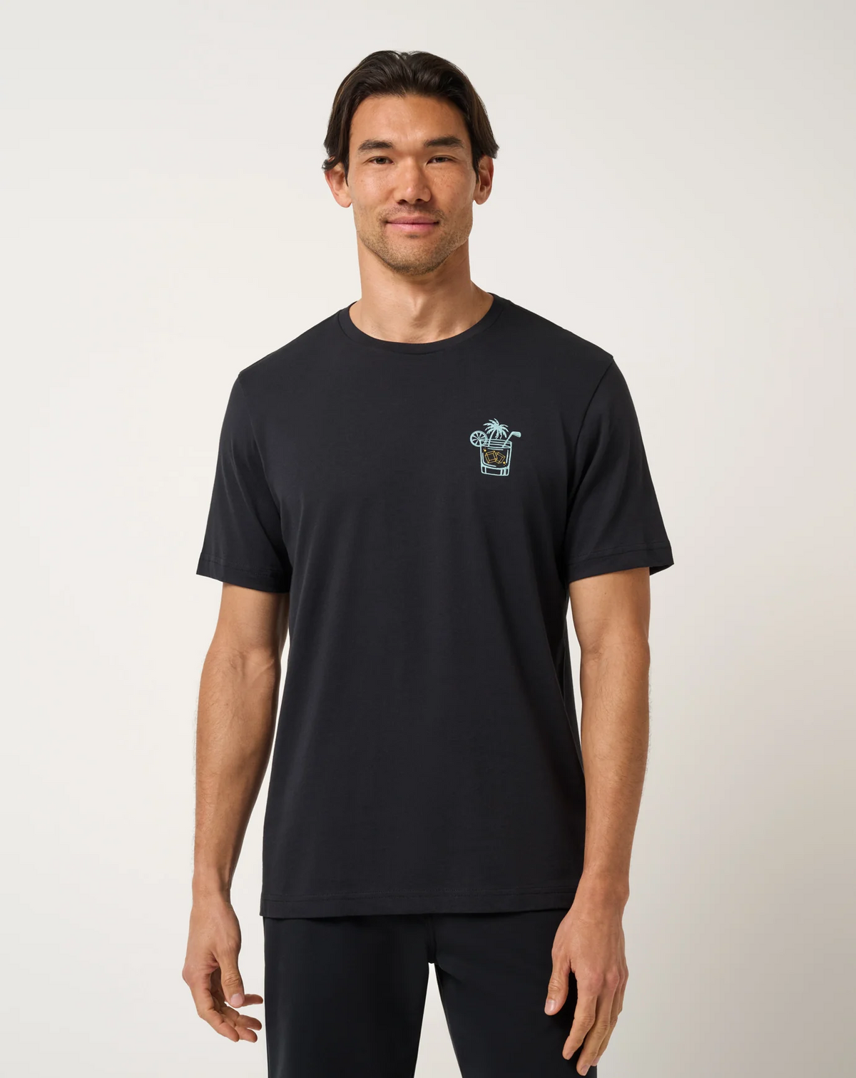 Front view of TravisMathew Beverage Cart Tee in black with minimal chest graphic detail