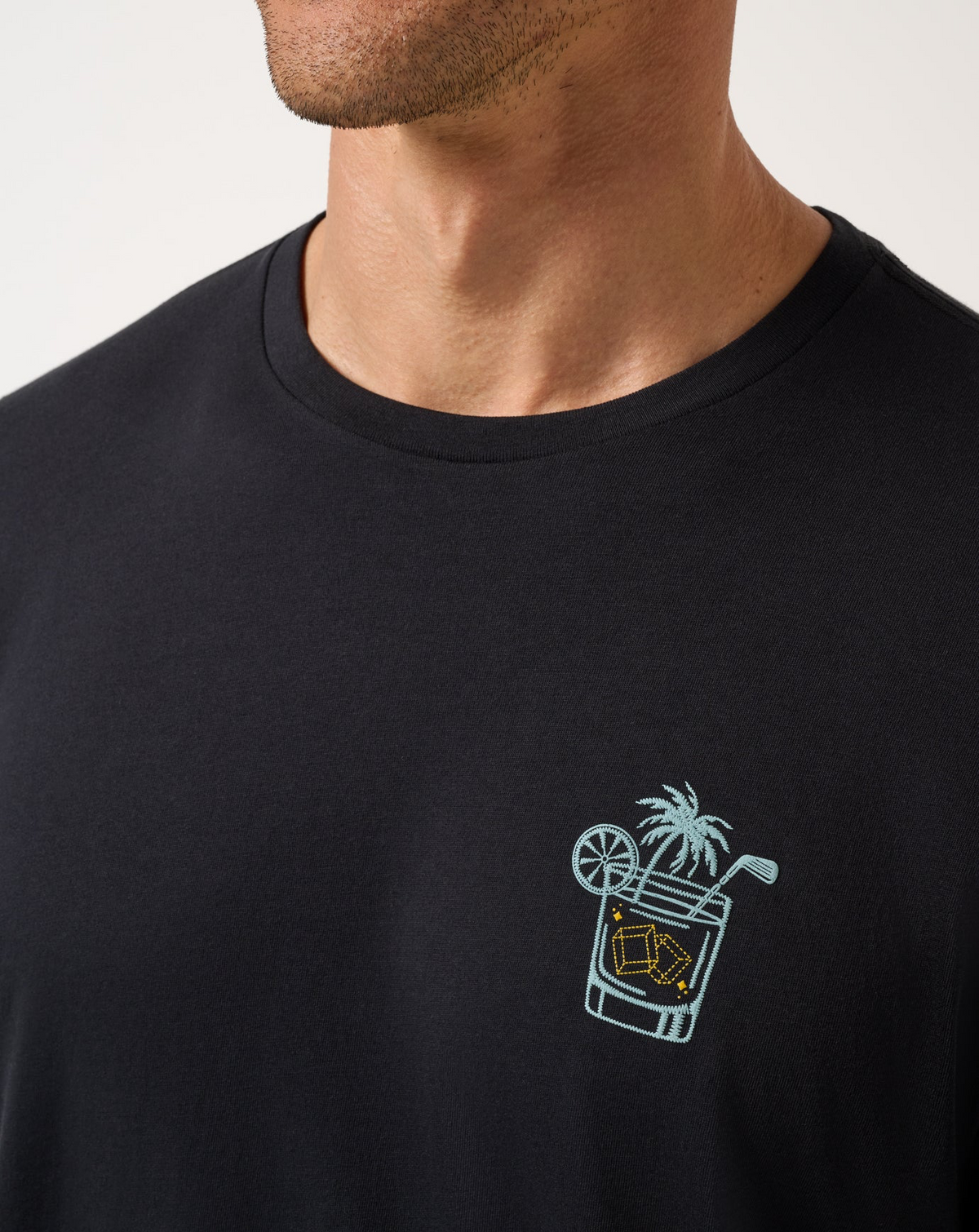 Close-up of TravisMathew Beverage Cart Tee chest graphic featuring cocktail and golf-inspired artwork