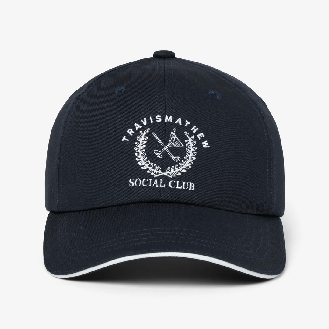 Front view of TravisMathew Social Club navy baseball cap with embroidered logo