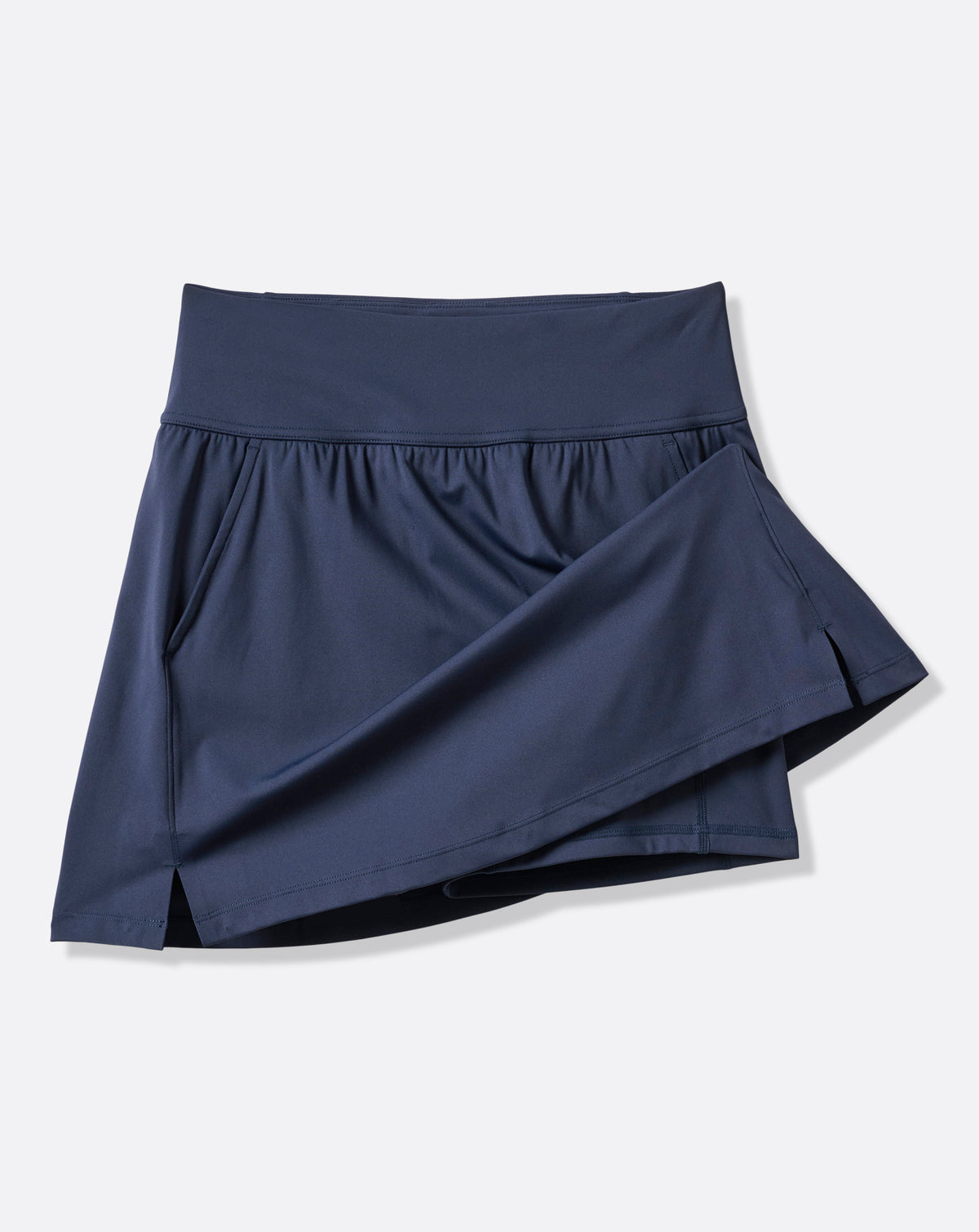 TravisMathew Moveknit Game Set Match Skort in navy, angled product view showing the bonded construction and side slit