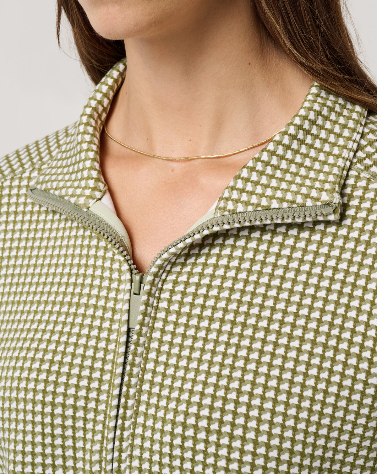 Close-up of TravisMathew women’s Printed Skyloft Soft Echo half zip pullover showing houndstooth print and zipper detail.