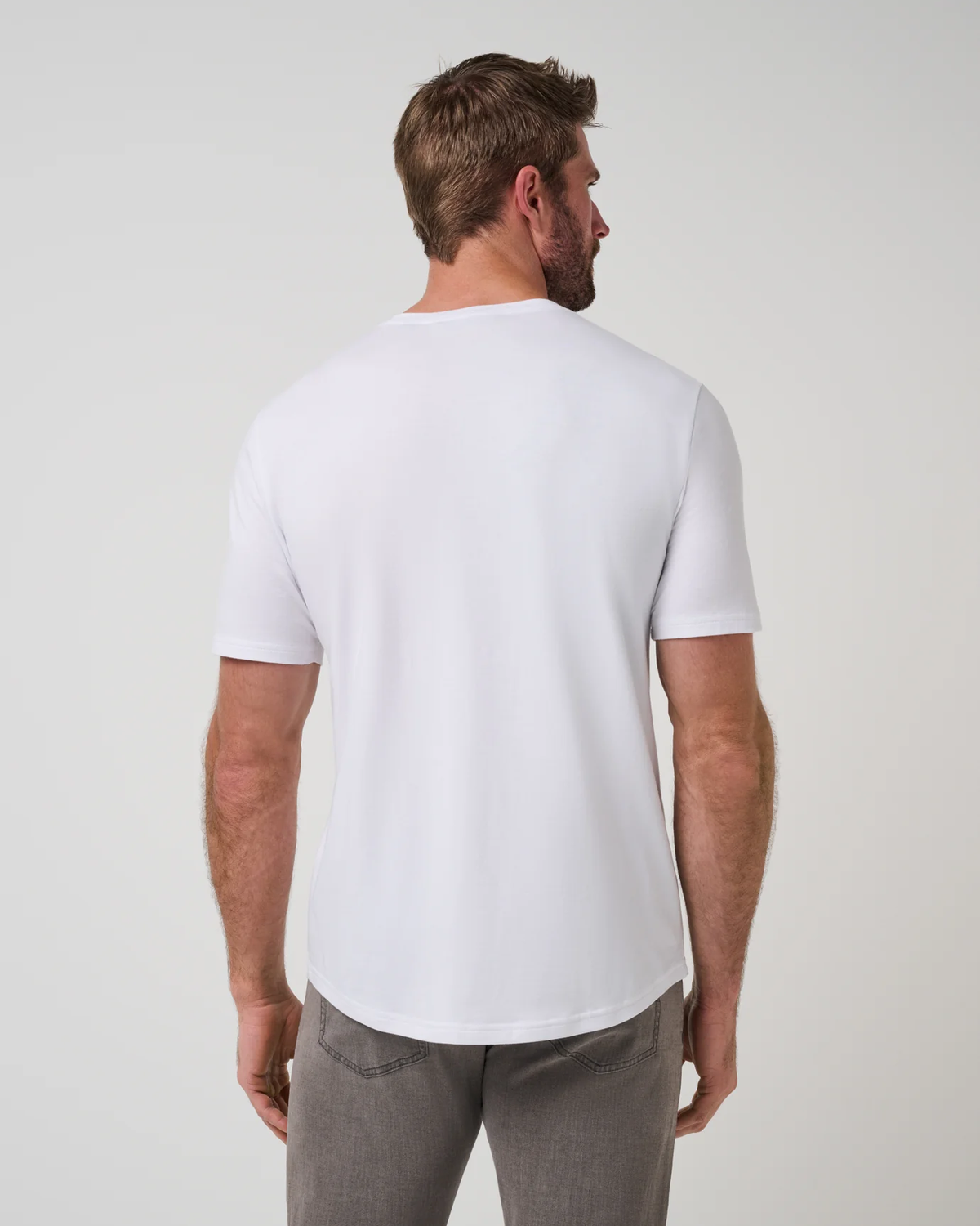 TravisMathew Cloud Henley Tee in white, back view on model showing the curved hem