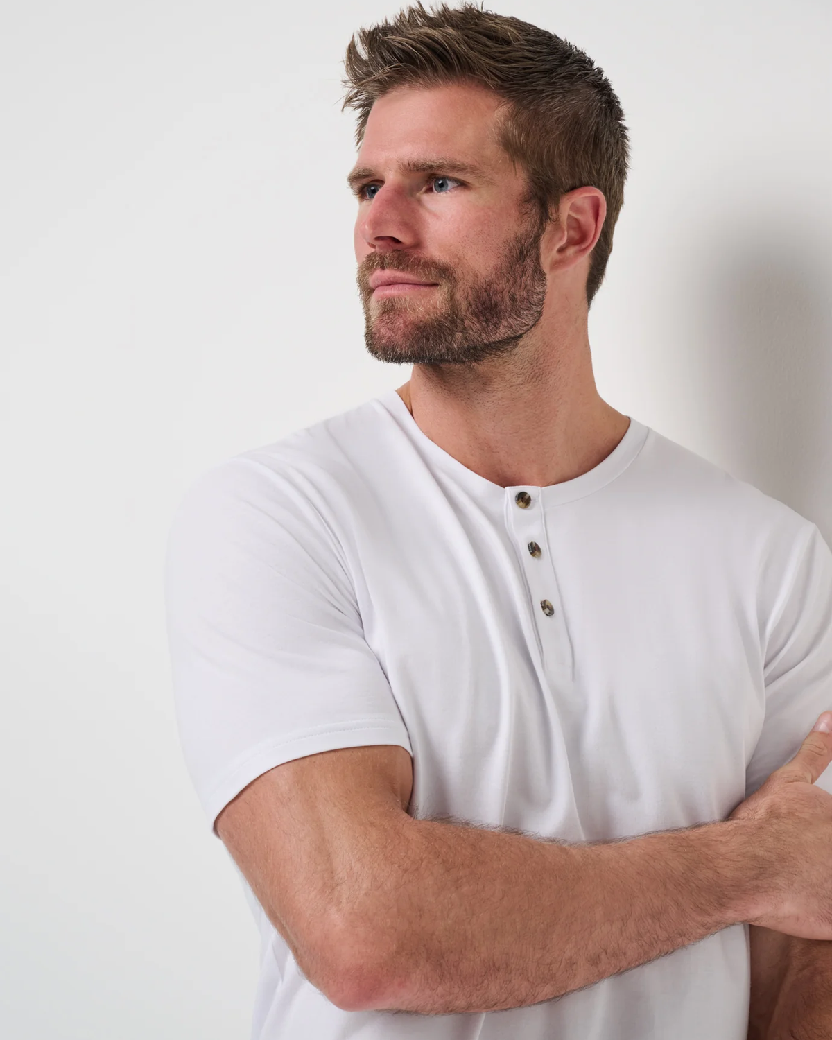 TravisMathew Cloud Henley Tee in white, upper body angle view on model showing the henley placket and soft Cloud Jersey fabric
