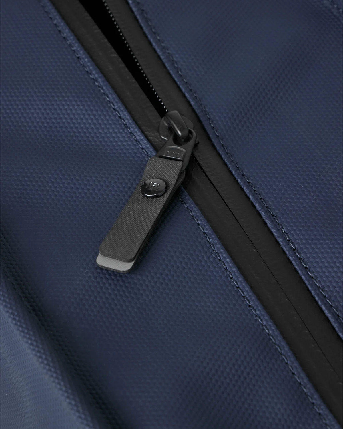 Close-up of the large zippered main opening on the TravisMathew Grab & Go Cooler Bag in Total Eclipse